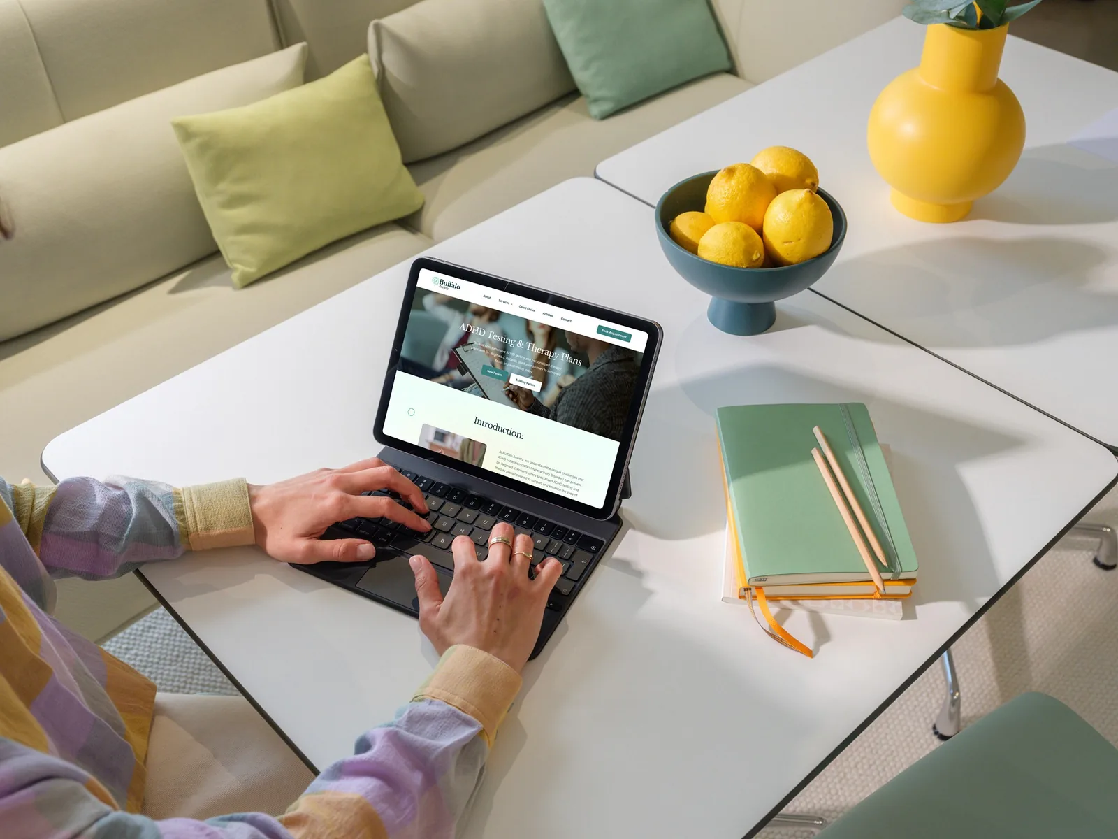 User typing on tablet displaying modern website design for therapy services.