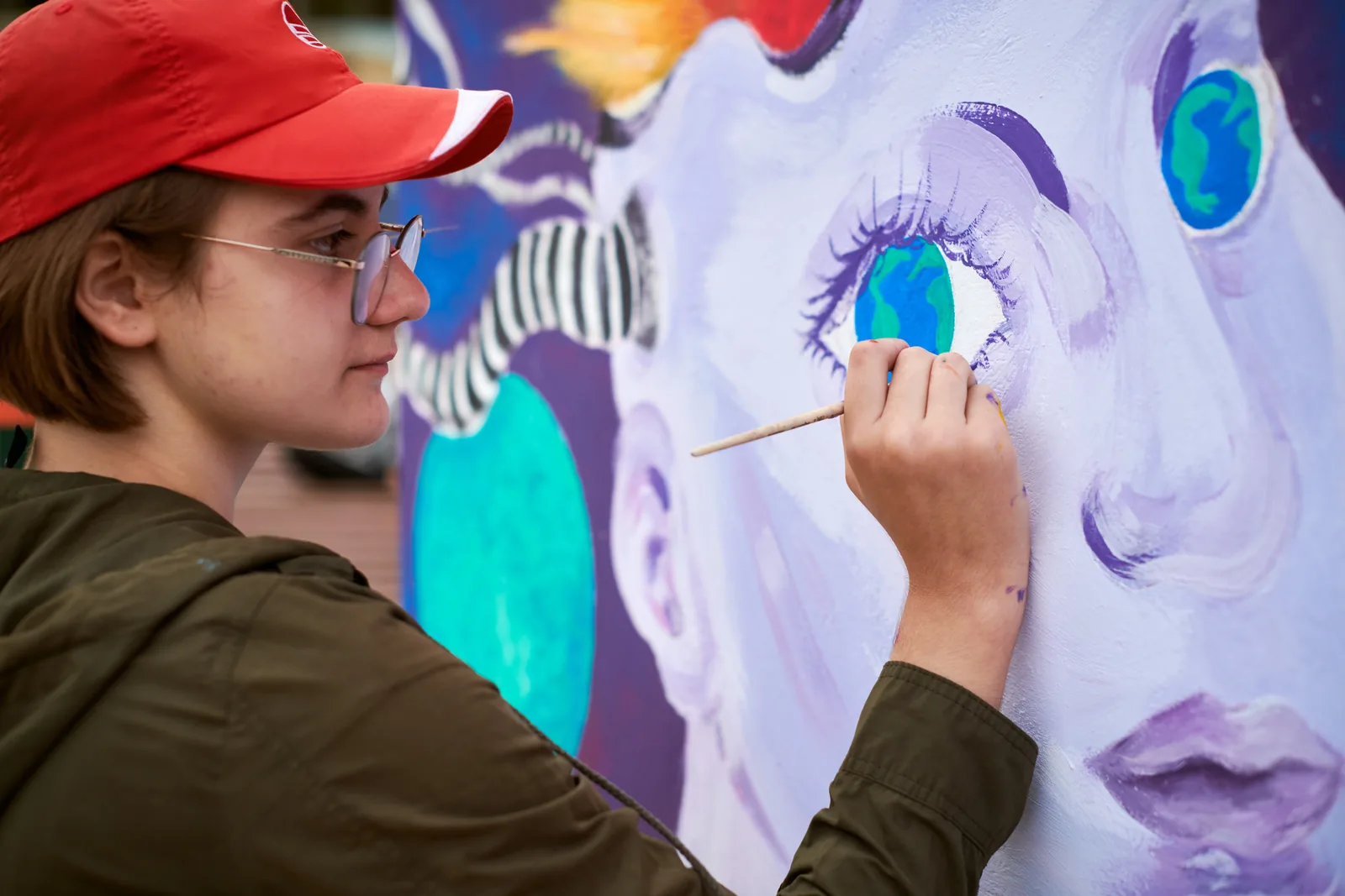 Artist painting a mural eye, reflecting the studio website design.