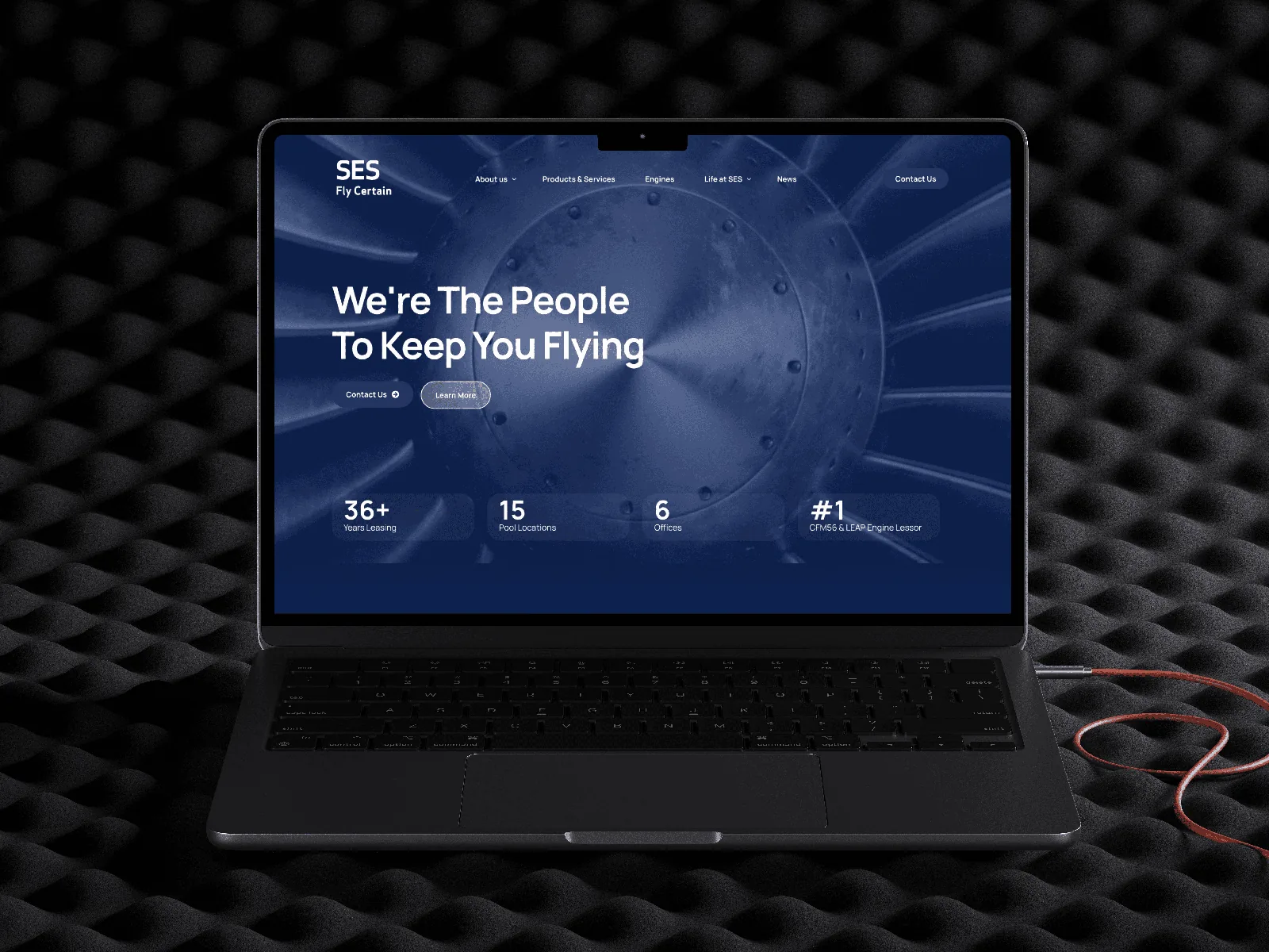 SES aviation website presented on a laptop with a turbine-inspired background